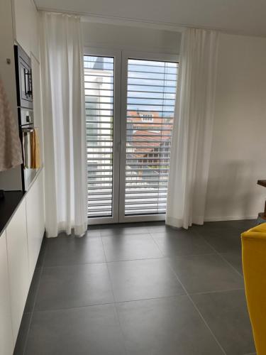 a living room with white curtains and a large window at Upper Floor in Oberburg