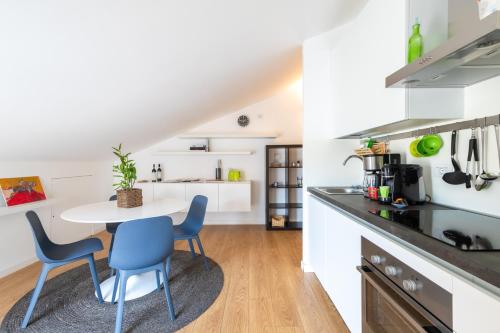 a kitchen with a table and chairs in a room at Modern Apartment with double terrace and parking in Alba