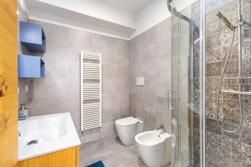a bathroom with a sink and a toilet and a shower at Modern Apartment with double terrace and parking in Alba