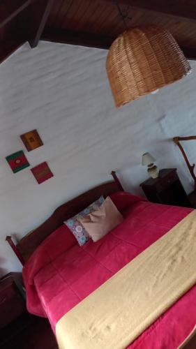 Un dormitorio con una cama con un edredón rojo. en la riviere, en Alta Gracia
