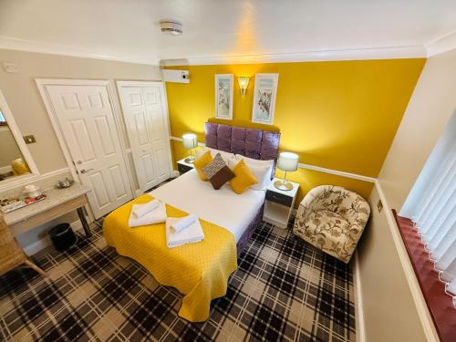 a small room with a bed and a chair at 4 Sisters Inn in Theydon Bois