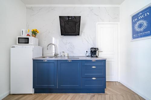 La cuisine bleue est équipée d'un évier et d'un réfrigérateur. dans l'établissement Studio moderne proche mer - Balcon et Climatisé, à Nice