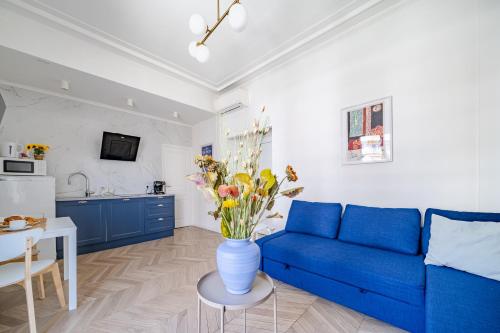 - un salon avec un canapé bleu et un vase de fleurs dans l'établissement Studio moderne proche mer - Balcon et Climatisé, à Nice