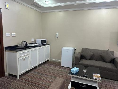a living room with a couch and a table at Pyramiza Fahaheel بيراميزا الفحيحيل in Kuwait