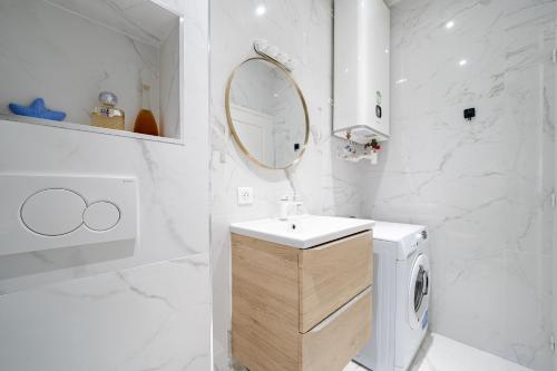 La salle de bains blanche est pourvue d'un lavabo et d'un lave-linge. dans l'établissement Studio moderne proche mer - Balcon et Climatisé, à Nice