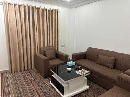 a living room with a couch and a chair and a table at Pyramiza Fahaheel بيراميزا الفحيحيل in Kuwait