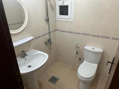 a bathroom with a white toilet and a sink at Pyramiza Fahaheel بيراميزا الفحيحيل in Kuwait