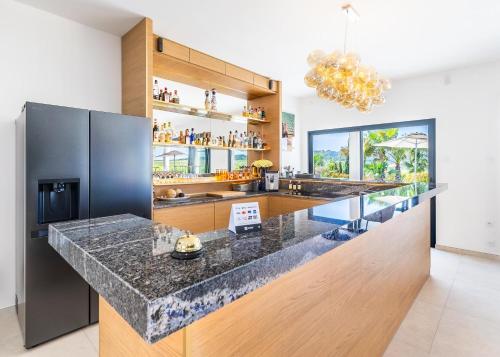 a kitchen with a large island with a counter top at Royal Tiki Lodges - Maison d'hôtes avec Piscine chauffée Jacuzzi- Chambres ou Villa entière - Villa SCL in Plaissan