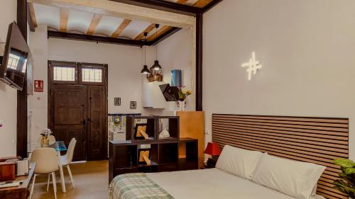 a bedroom with a bed and a desk and a table at casa del Cabanyal La Playa in Valencia