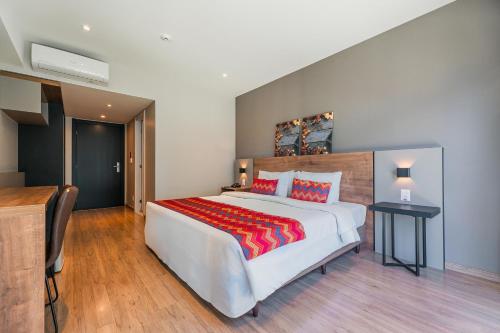 a large bedroom with a large white bed with red pillows at Laghetto Stilo Vita in Gramado