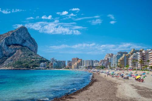 a beach in positano with people and buildings at Apolo XI, Calpe, Modern Holiday Apartment, Sea view, Pool, 100m to Beach! in Calpe