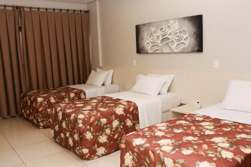 a hotel room with two beds in a room at Hotel Relicário in Araguaína