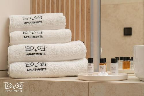 een stapel handdoeken op een plank in een badkamer bij Zielona 16 D&D Apartments in Międzywodzie