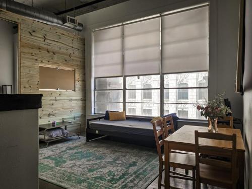 a room with a bed and a table and a window at The Downtown Factory Loft in Memphis