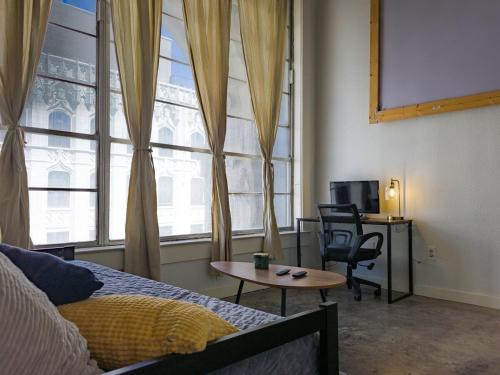 a bedroom with a bed and a table and a window at The Downtown Factory Loft in Memphis