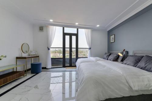 a bedroom with a large bed and a large window at Aura Apartment l Căn Hộ Trung Tâm Đà Lạt l View Đẹp, Bếp, Ban Công in Xuan An