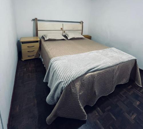 a bedroom with a bed and a nightstand with a bed sidx sidx sidx sidx at Casa com 2 quartos Mobiliada próxima ao Batel e Parque Barigui in Curitiba