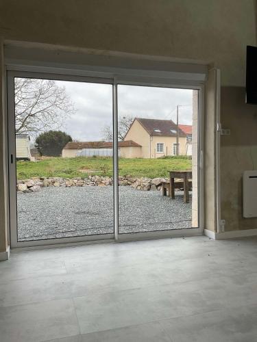 a sliding glass door with a view of a yard at BERRY's CHARM in Le Pêchereau