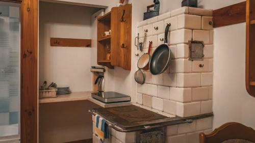 a kitchen with a stove with pots and pans on the wall at Pokoje Gościnne Wojtek-2 in Białowieża