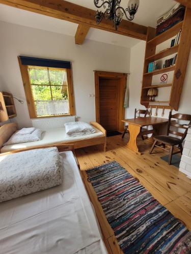a living room with two beds and a table at Pokoje Gościnne Wojtek-2 in Białowieża