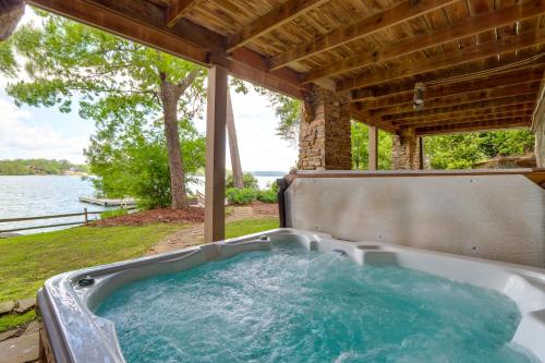 a jacuzzi tub sitting under a porch next to the water at Waterfront Escape on Blue Ridge Lake with Dock! in Morganton