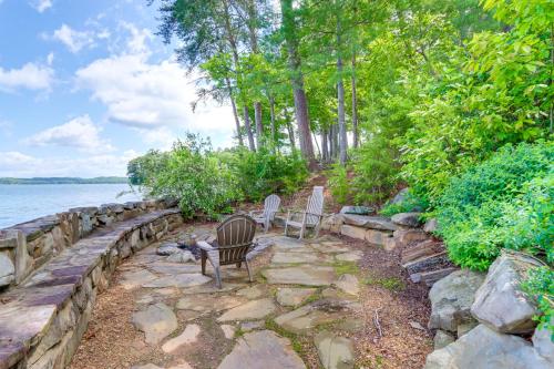 a couple of chairs sitting on a stone path next to the water at Waterfront Escape on Blue Ridge Lake with Dock! in Morganton