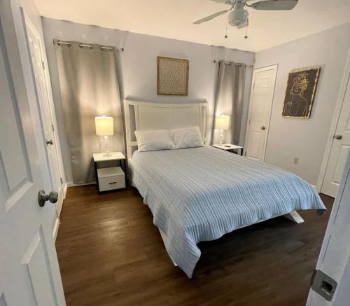 a bedroom with a bed with two night stands and two lamps at Cozy 2BR 2BA apt close to Siegen & Womans in Baton Rouge