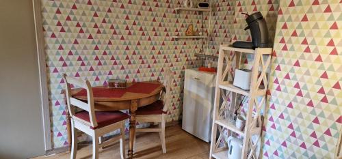 a dining room with a table and a geometric wall at La chambre des As in Durbuy