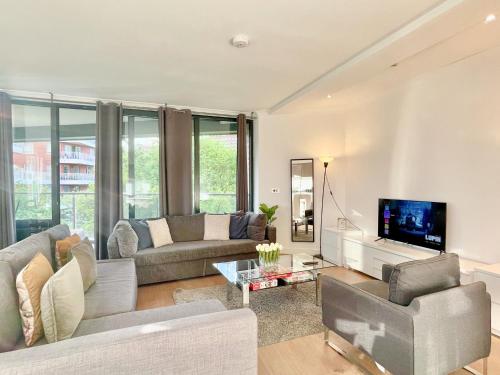 a living room with a couch and a tv at Sleek 3-bedroom flat with Balcony, Lift access, FREE WiFi in Southwark, Borough near The Shard by Staylio London in London