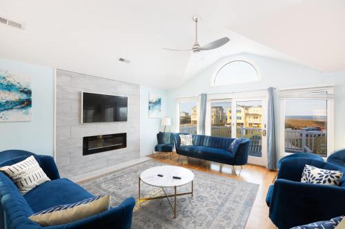 a living room with blue furniture and a fireplace at Semi Ocean Front Luxury Home Pool Spa Game Room in Duck