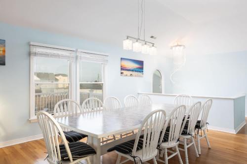 a white dining room with a table and chairs at Semi Ocean Front Luxury Home Pool Spa Game Room in Duck