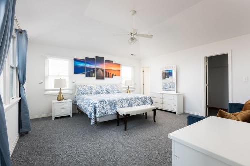 a white bedroom with a bed and a couch at Semi Ocean Front Luxury Home Pool Spa Game Room in Duck