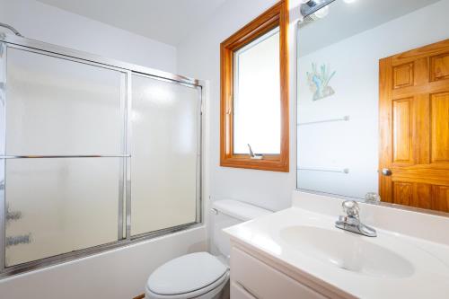 a bathroom with a shower and a toilet and a sink at Semi Ocean Front Luxury Home Pool Spa Game Room in Duck