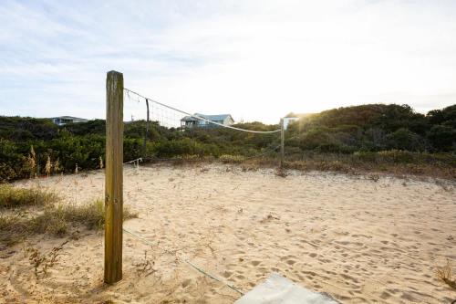 a volleyball net on the sand on a beach at Semi Ocean Front Luxury Home Pool Spa Game Room in Duck