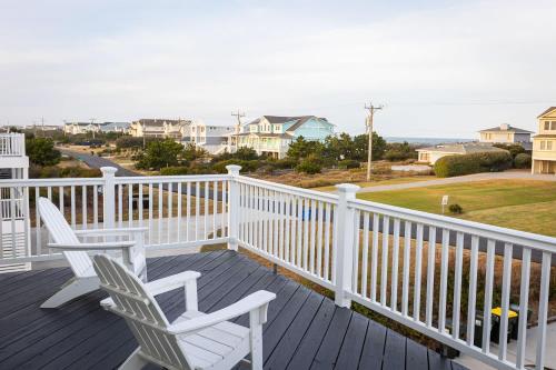 two chairs on a deck with a view of the ocean at Semi Ocean Front Luxury Home Pool Spa Game Room in Duck