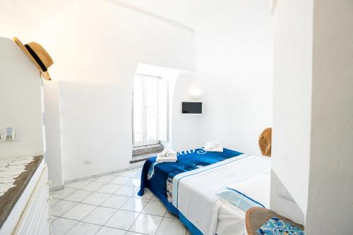 a white room with a bed and a window at La Dolce Vita By Fantasy in Forio d'Ischia