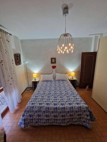 a bedroom with a bed and a chandelier at Casa Kelly in Luni