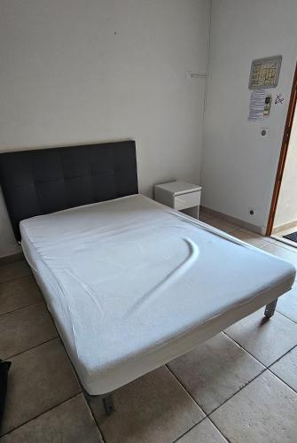 Ce lit se trouve dans un dortoir doté d'un matelas blanc. dans l'établissement Studio Meublé-Juan Pins-Logt2, à Antibes
