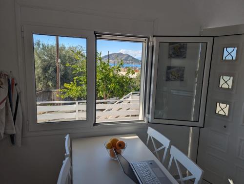 a room with a table and two windows and a keyboard at Bay view in Salamís