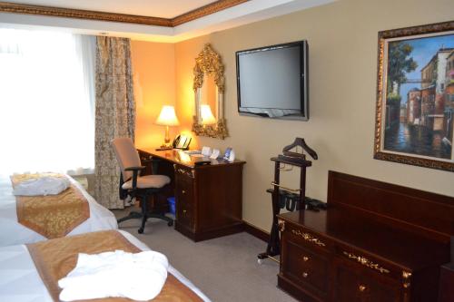 a hotel room with a desk and a tv on the wall at Radisson Hotel Toronto Airport West in Mississauga