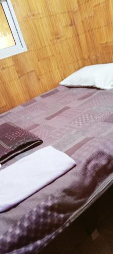 a bed with purple sheets and white pillows on it at JUNGLE GYM LA UNION Prana fan kubo 2 pax in Rimus