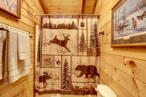 Un baño con una cortina de ducha con ciervos. en 1 Mi to Current River Cozy Studio Cabin!, en Van Buren