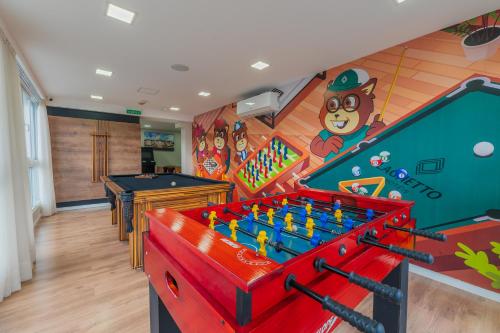a room with pool tables and a mural at Laghetto Stilo Vita in Gramado