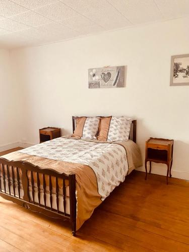 une chambre avec un lit et deux tables de nuit dans l'établissement La Chtite Campagnarde de Saône, 