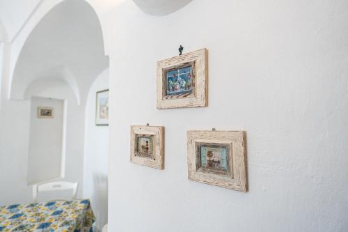 four framed paintings on a wall in a room at La Dolce Vita By Fantasy in Forio d'Ischia