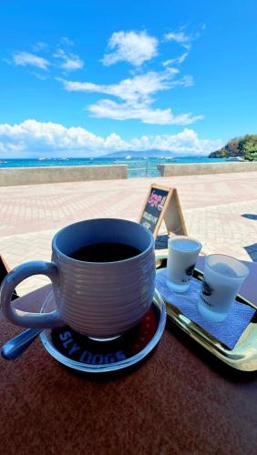 a cup of coffee sitting on a plate on a table at Family 2 bed apartment with stunning sea views in Puerto Galera