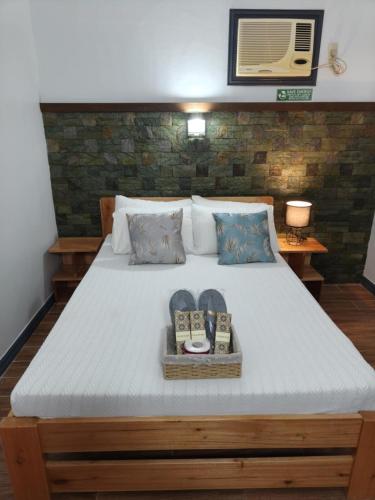 a bed with a tray with two books on it at Family 2 bed apartment with stunning sea views in Puerto Galera