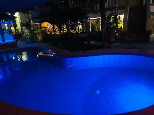 a large swimming pool lit up at night at Family 2 bed apartment with stunning sea views in Puerto Galera
