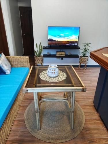 a living room with a coffee table and a tv at Family 2 bed apartment with stunning sea views in Puerto Galera