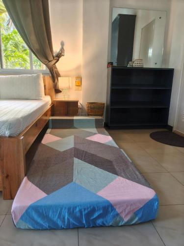 a bedroom with a bed and a rug on the floor at Family 2 bed apartment with stunning sea views in Puerto Galera
